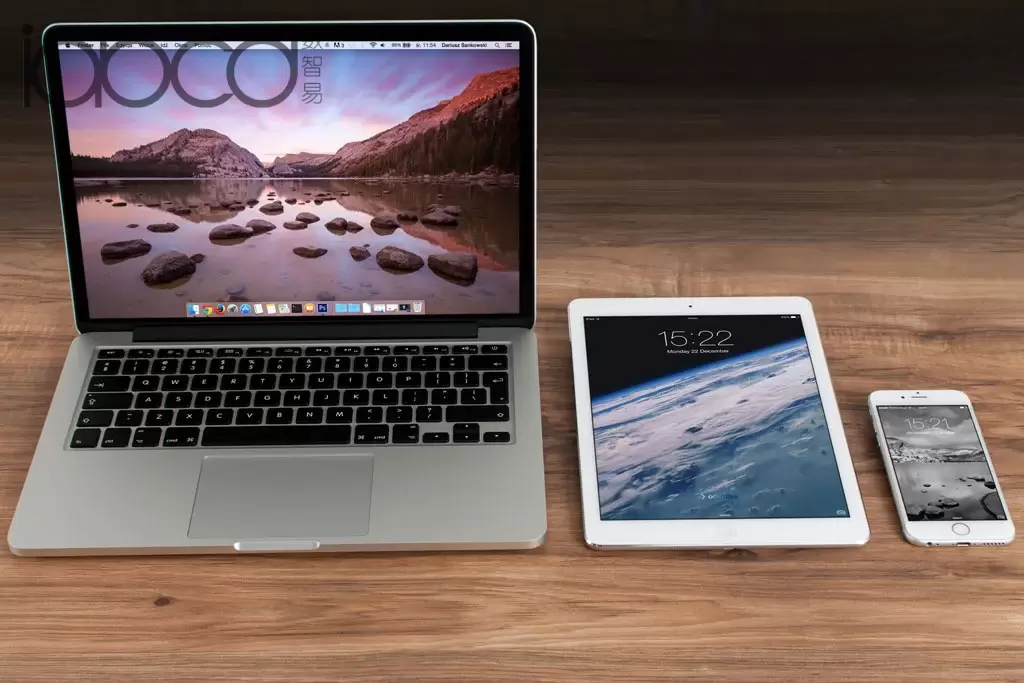 一台 MacBook iPad 和一台 iPhone 并排放在桌子上